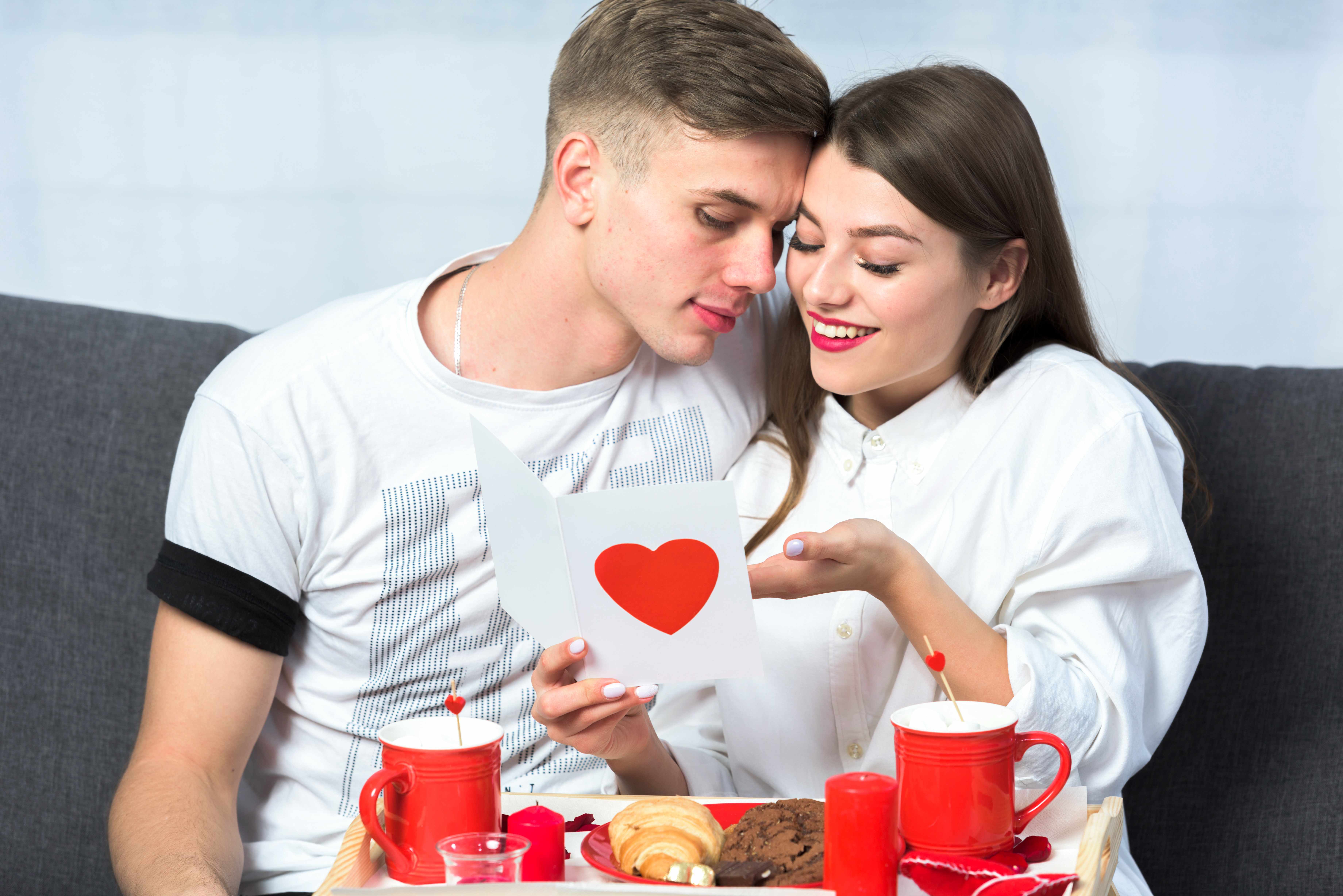 young couple reading greeting card couch